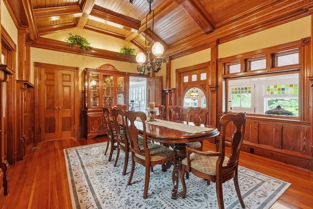 a dining room with furniture a chandelier and wooden floor