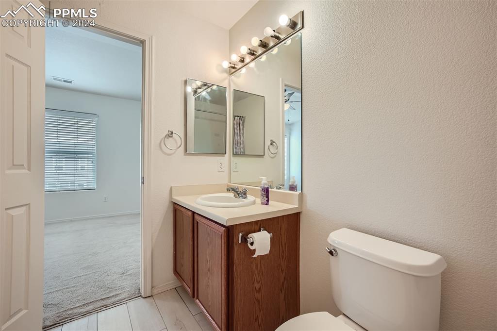 10581 Wells Point Fountain, CO 80817 - Photo 17 of 23 a bathroom with a granite countertop toilet a sink and a mirror