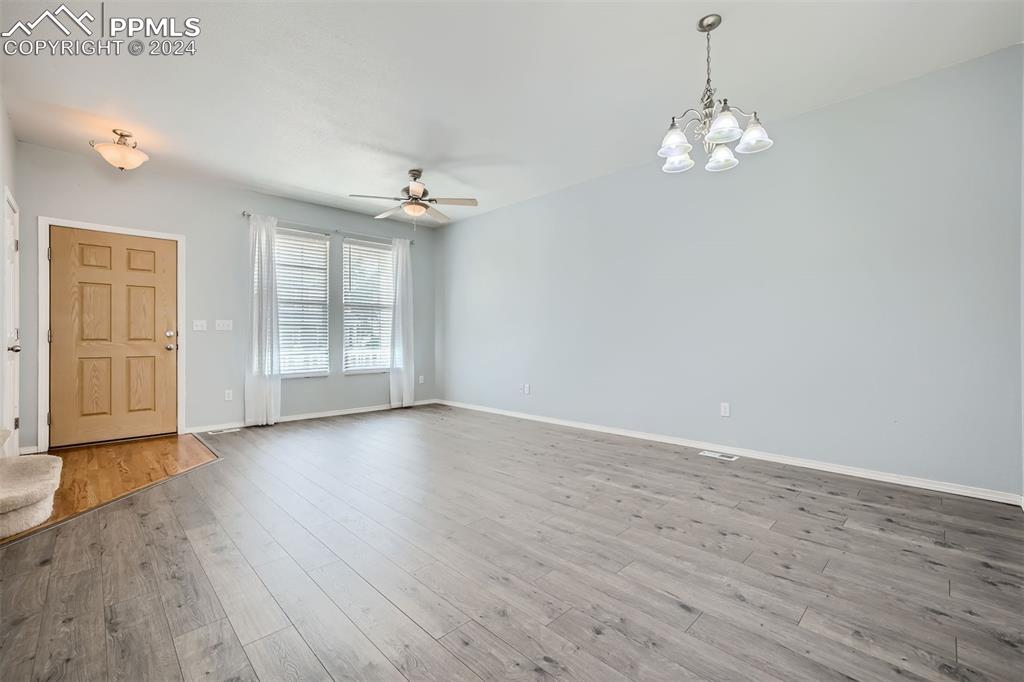 10581 Wells Point Fountain, CO 80817 - Photo 3 of 23 an empty room with wooden floor chandelier and windows