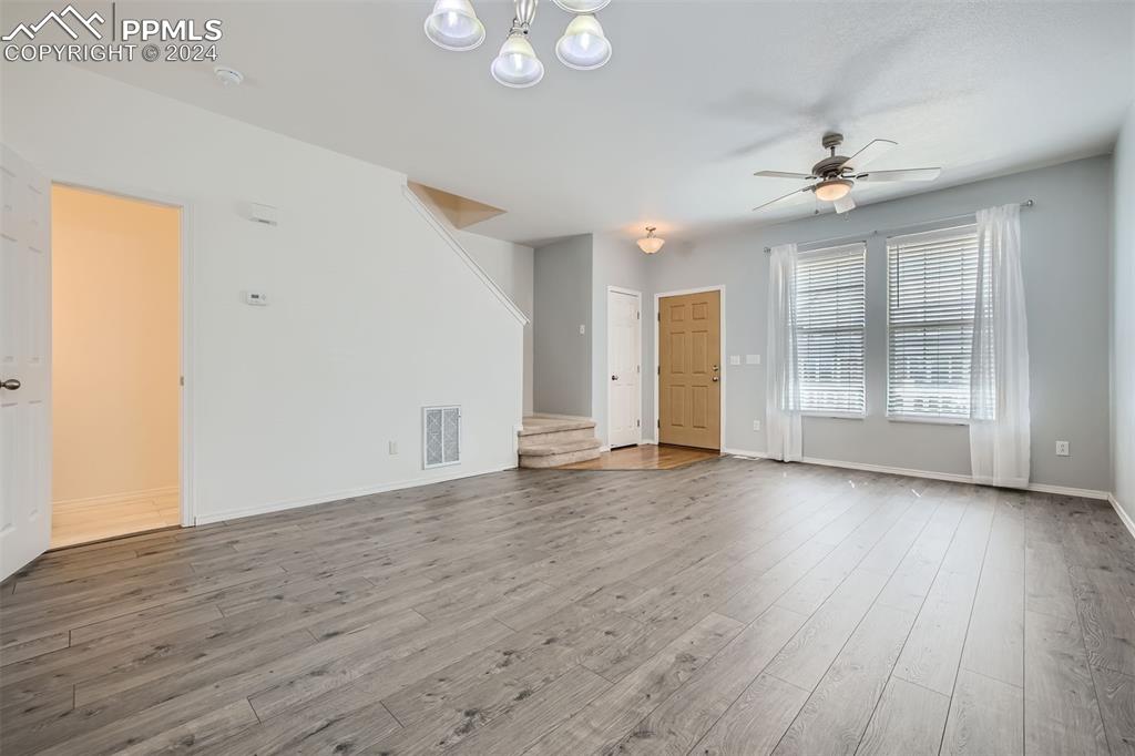 10581 Wells Point Fountain, CO 80817 - Photo 6 of 23 an empty room with wooden floor ceiling fan and windows