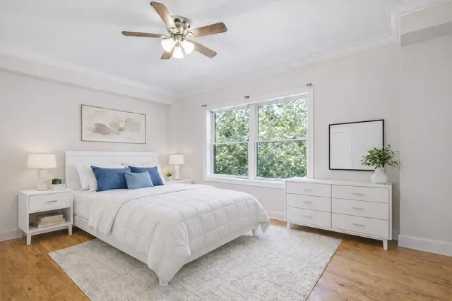 a bedroom with a bed chandelier and a window