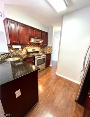 a kitchen with granite countertop stainless steel appliances and wooden cabinets