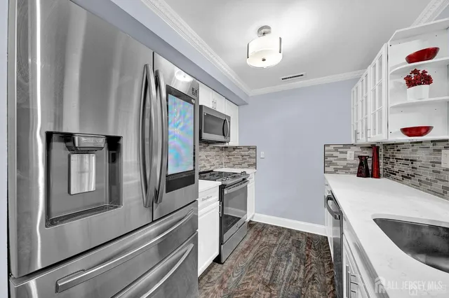 a kitchen with stainless steel appliances granite countertop a refrigerator and a stove