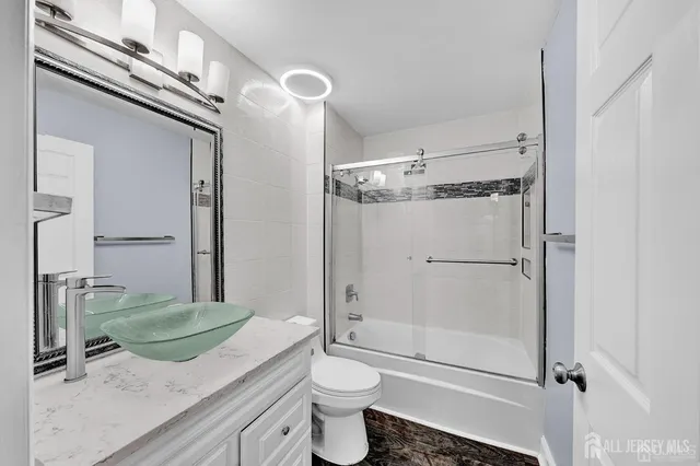 a bathroom with a granite countertop sink toilet and shower
