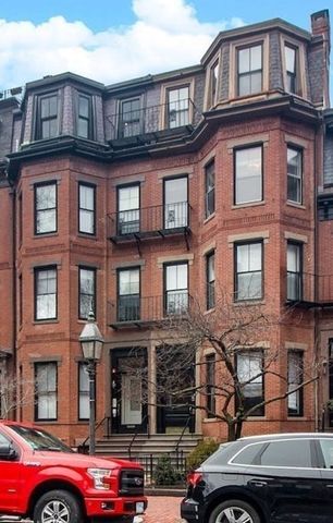 a front view of a building with car parked