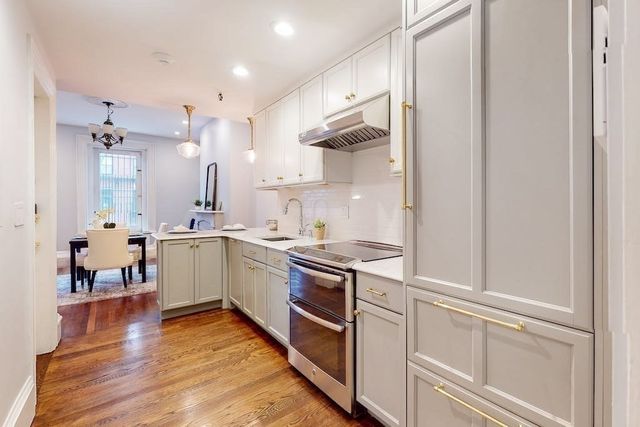 a kitchen with a sink cabinets and wooden floor