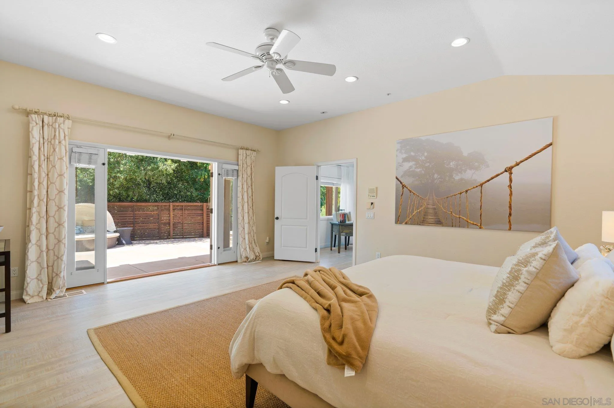 3111 Brookside Lane Encinitas, CA 92024 - Photo 13 of 40 a spacious bedroom with a large bed and a chandelier