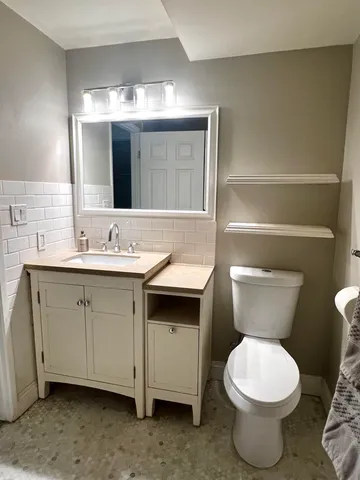 a bathroom with a toilet sink and mirror