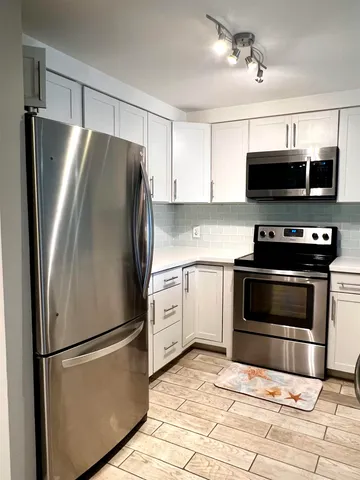 a kitchen with stainless steel appliances a refrigerator a stove a microwave and cabinets