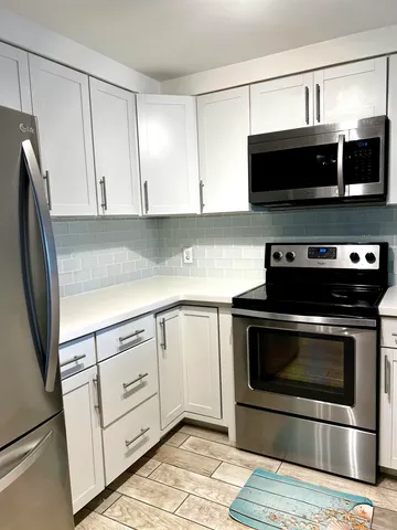 a kitchen with stainless steel appliances a stove a microwave and sink