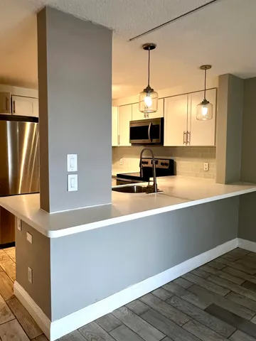 a kitchen with stainless steel appliances a sink and a refrigerator