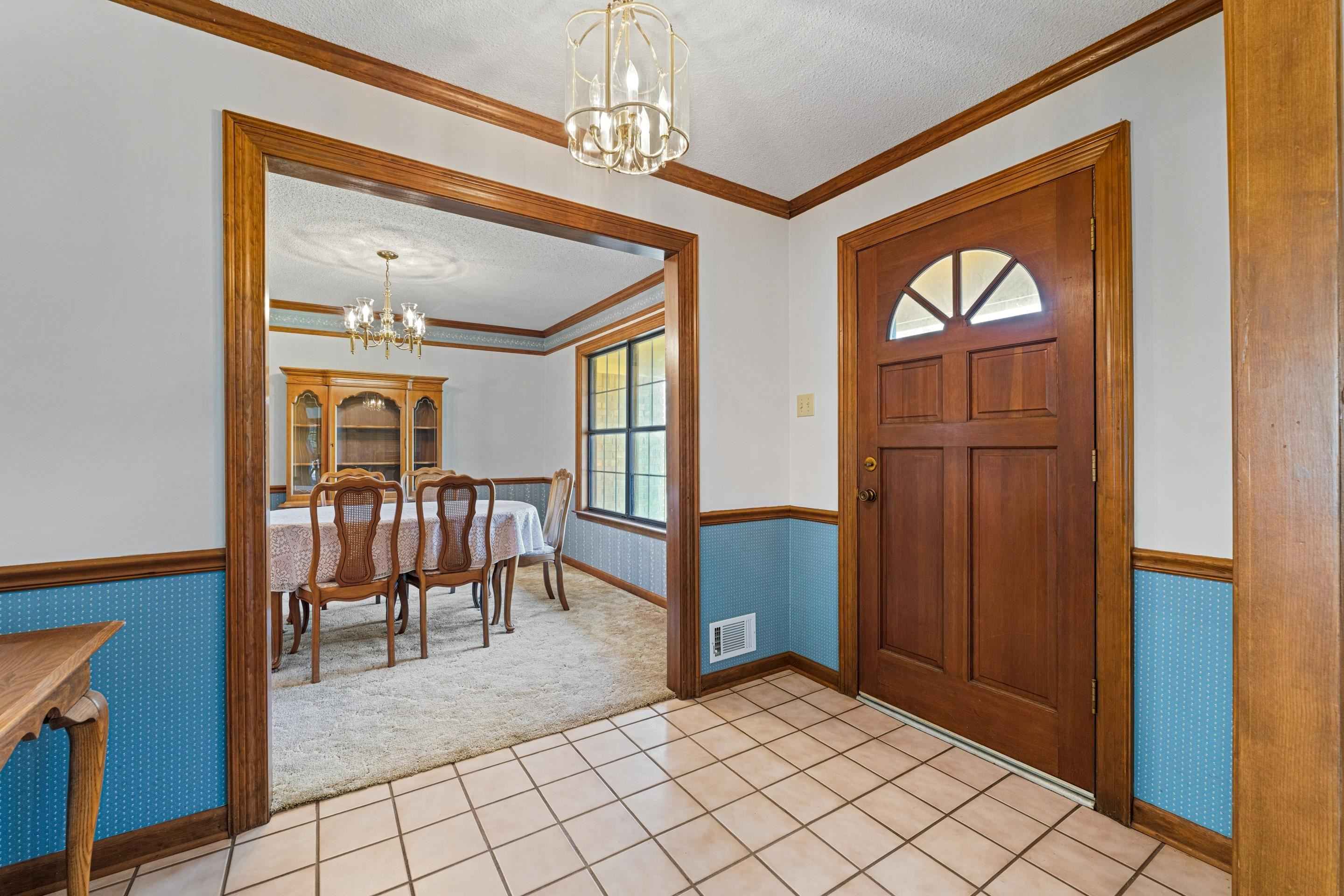 650 Blain Road Rossville, TN 38066 - Photo 6 of 26 The entryway greets guests with a soft glow from a delicate chandelier, tile flooring underfoot, and sightlines that open to both the formal dining room and the main living area. It’s a welcoming introduction to a home designed for gathering.