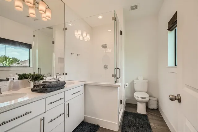 a bathroom with a double vanity sink toilet and shower