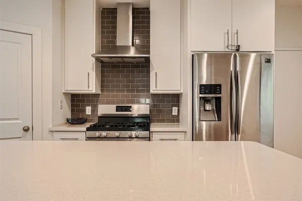 a kitchen with stainless steel appliances a refrigerator and a stove top oven