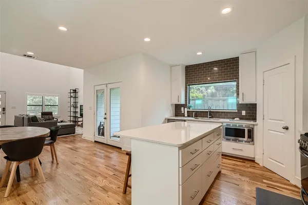 a kitchen that has a lot of cabinets in it and wooden floors