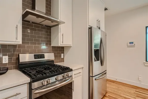 a kitchen with stainless steel appliances granite countertop a refrigerator and a stove