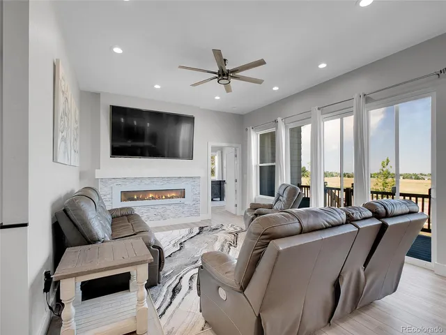 a living room with furniture a flat screen tv and a large window