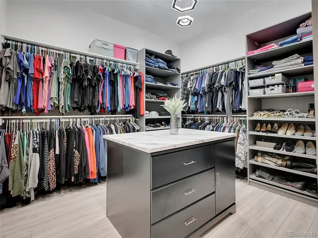 a view of walk in closet with clothes and shoes