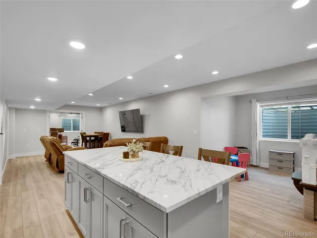 a kitchen with stainless steel appliances kitchen island granite countertop a sink dishwasher and a stove with wooden floor