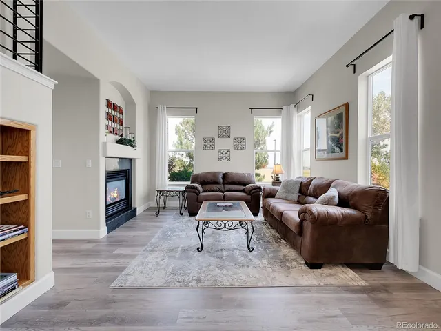 a living room with furniture a fireplace and a flat screen tv