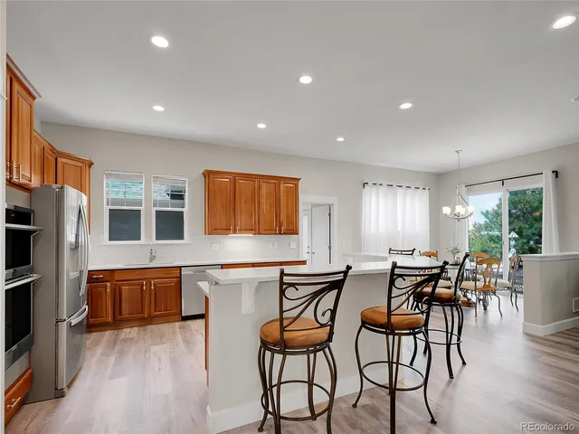 a dining room with furniture a chandelier and wooden floor
