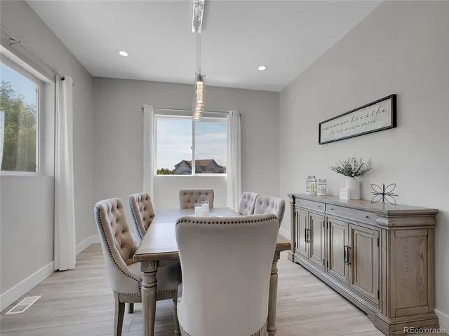 a dining room with furniture a wooden floor and a chandelier