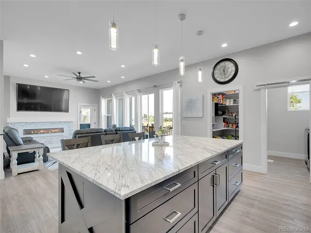 a kitchen with stainless steel appliances granite countertop a sink dishwasher and a flat screen tv