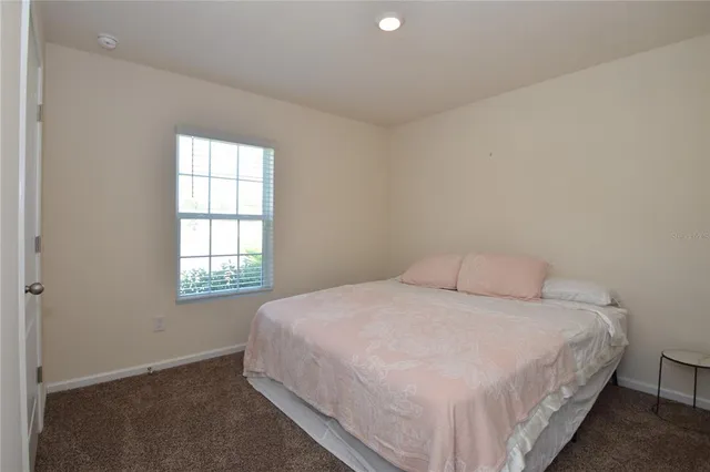 a large bed sitting in a bedroom next to a window
