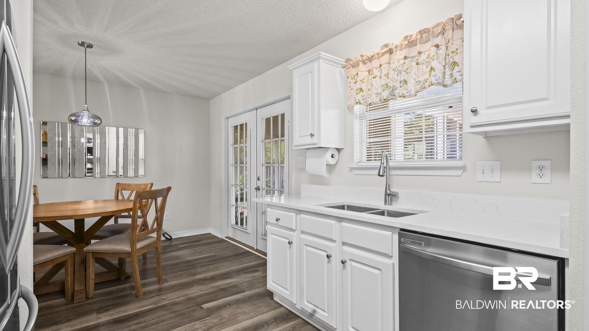 302 Cluster Street Foley, AL 36535 - Photo 16 of 28 Kitchen with stainless steel dishwasher, dark wood-style floors, light countertops, refrigerator, and a textured ceiling