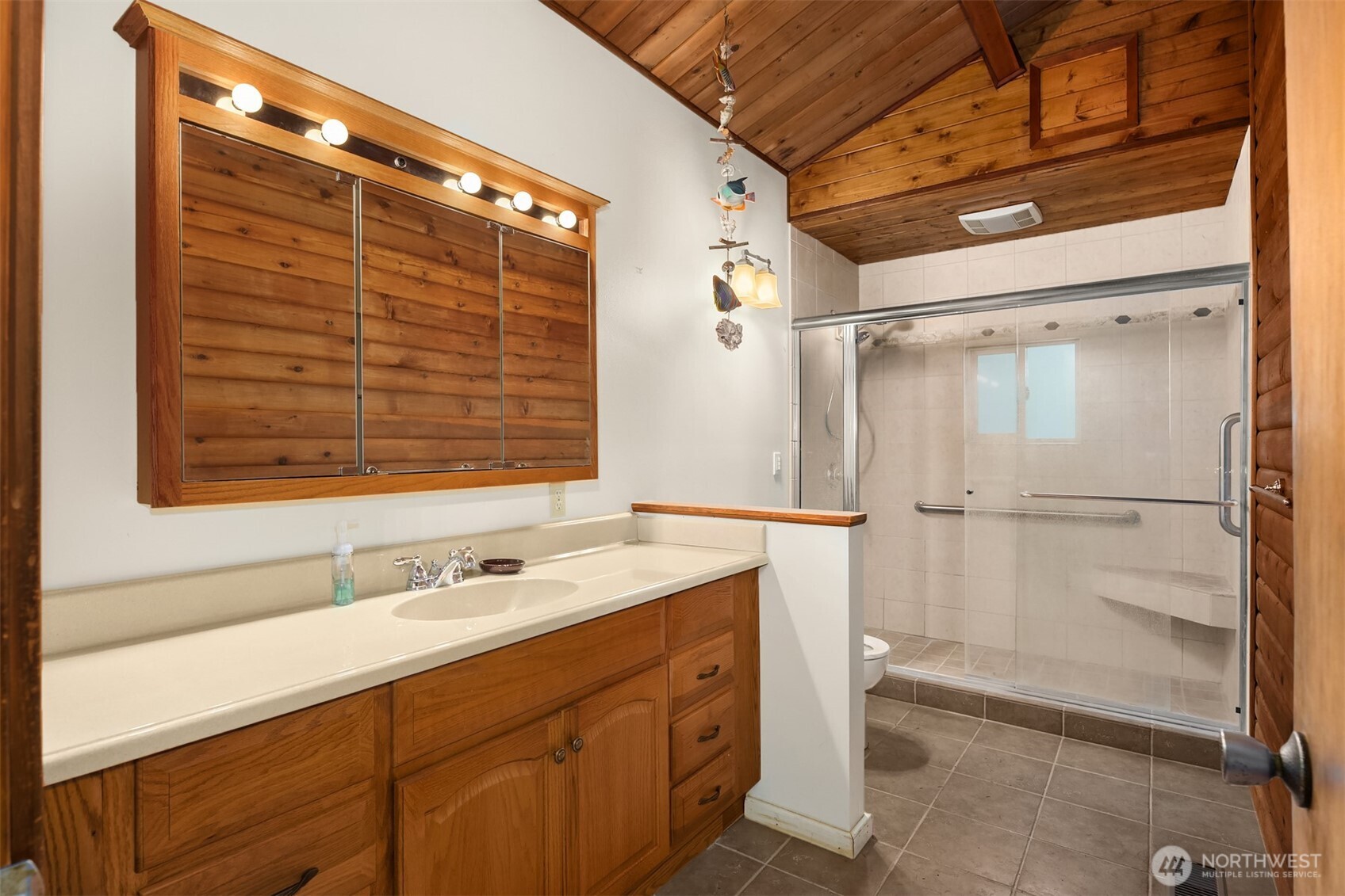 10862 Falk Road Northeast Bainbridge Island, WA 98110 - Photo 23 of 34 a bathroom with a shower sink and vanity