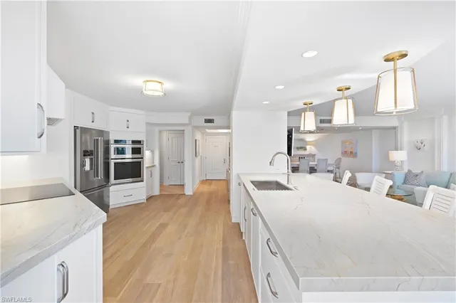 a large white kitchen with stainless steel appliances