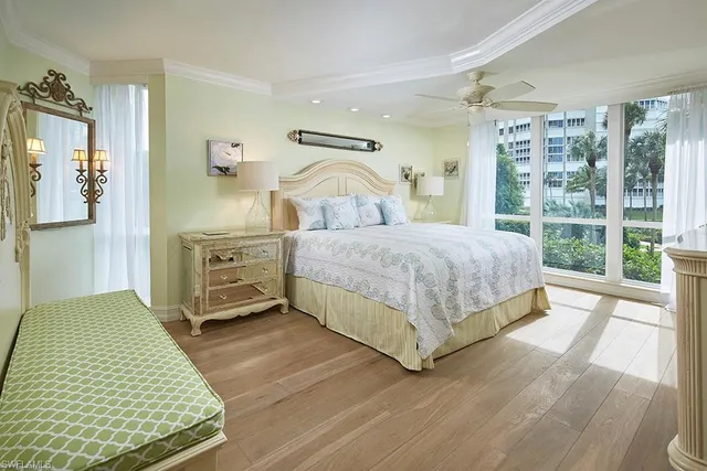 a bedroom with a bed lamp and a large window