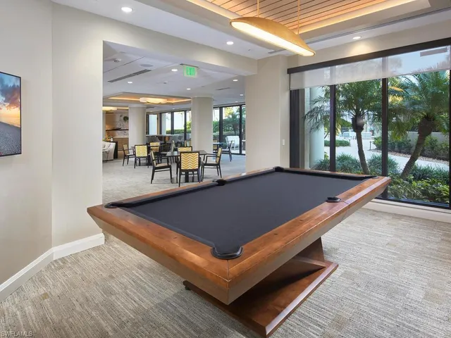 a room with pool table and windows
