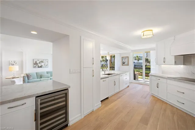 a large kitchen with kitchen island white cabinets and stainless steel appliances