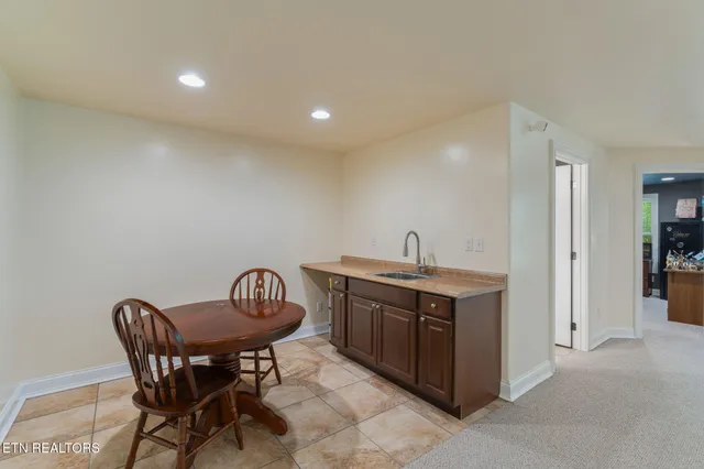 a kitchen with a sink and chairs