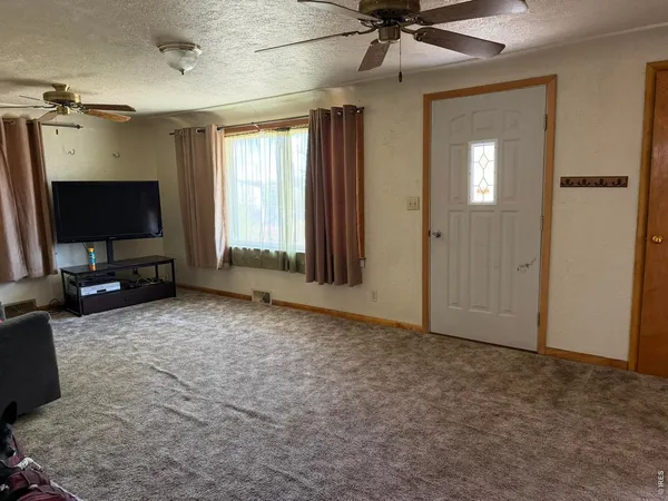 an empty room with windows and flat screen tv