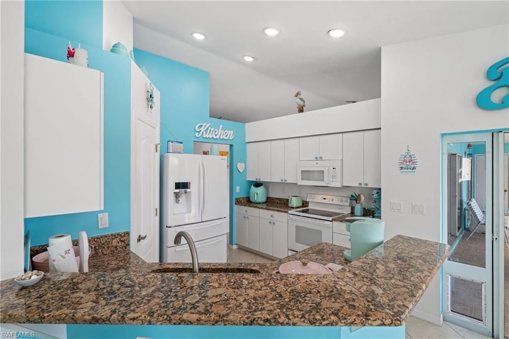 1408 Southwest 23rd Street Cape Coral, FL 33991 - Photo 39 of 49 a kitchen with stainless steel appliances granite countertop a refrigerator sink and stove