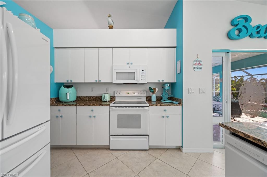 1408 Southwest 23rd Street Cape Coral, FL 33991 - Photo 40 of 49 a kitchen with stainless steel appliances granite countertop white refrigerator stove a sink and dishwasher
