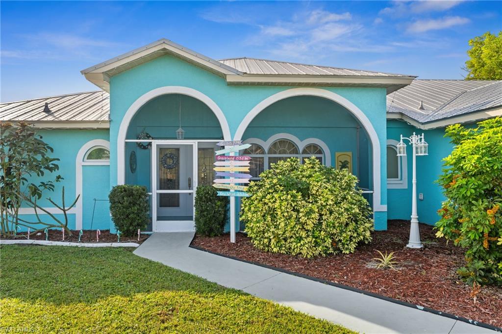 1408 Southwest 23rd Street Cape Coral, FL 33991 - Photo 8 of 49 a front view of a house with garden