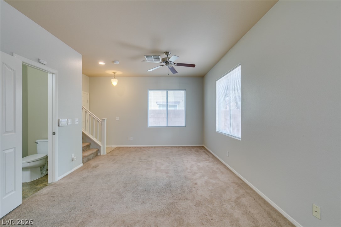 8937 Caledon Ridge Court Las Vegas, NV 89149 - Photo 7 of 43 A spacious living area with warm carpet flooring, featuring a ceiling fan and abundant natural illumination.