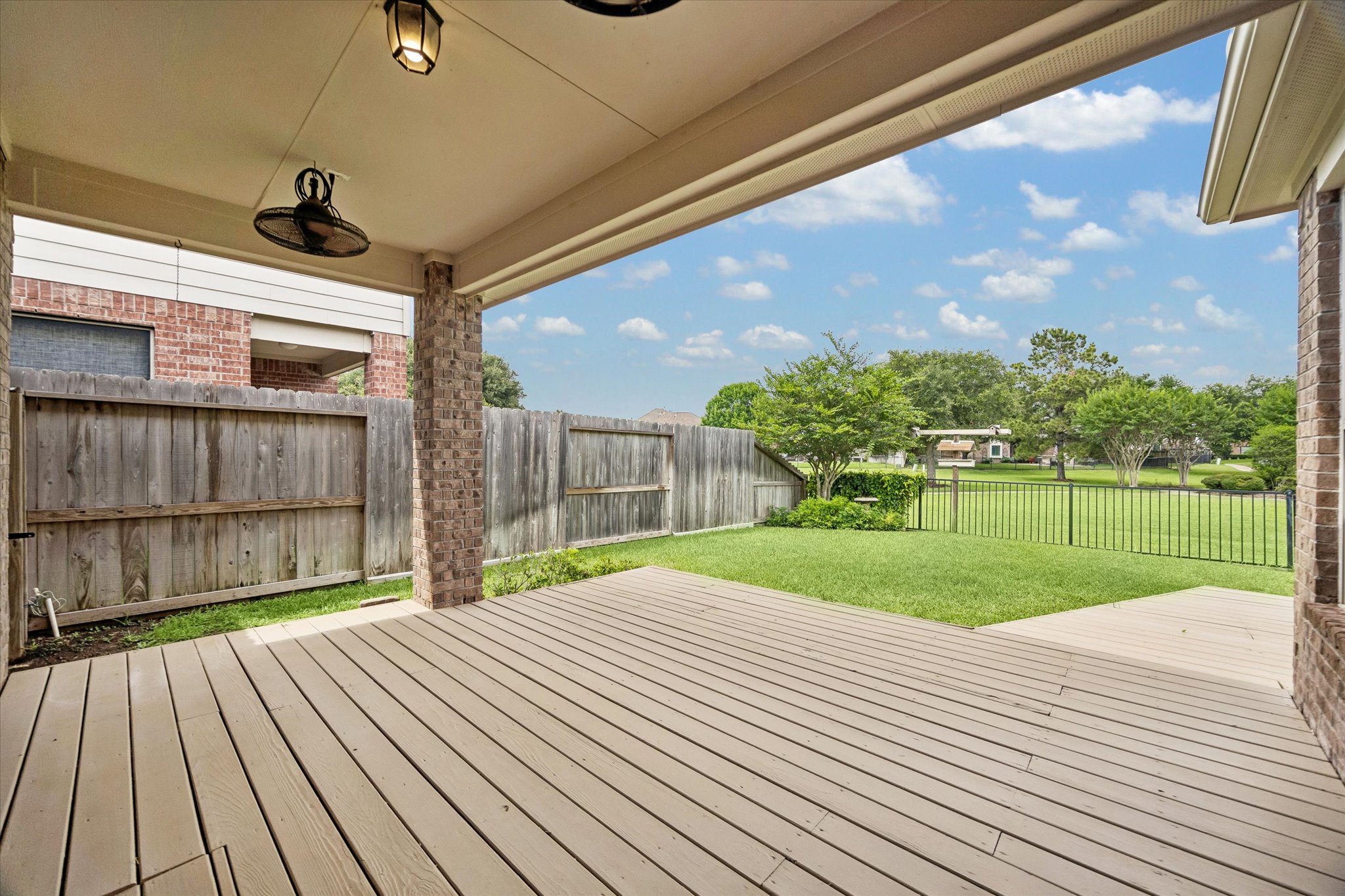 2214 Wembley Way Rosenberg, TX 77471 - Photo 15 of 35 Expansive covered patio featuring a full-width deck, integrated ceiling fan, and overhead lighting