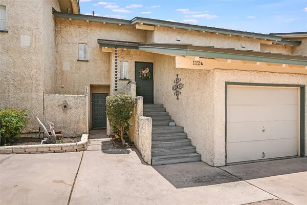 a view of a house with barbeque grill and wooden fence