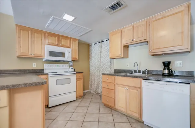 a kitchen with white cabinets a sink and white appliances