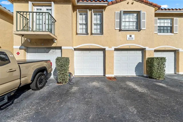 a view of a house with a yard and parking space