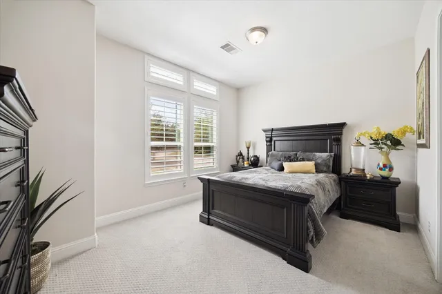 a bed sitting in a spacious bedroom next to a window