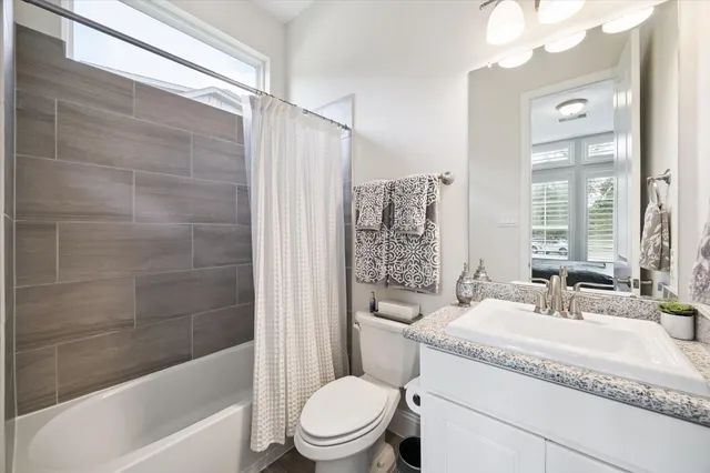 a bathroom with a granite countertop sink toilet and shower