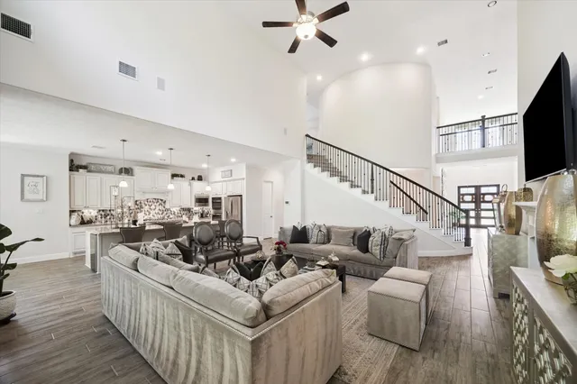 a living room with furniture kitchen view and a large window