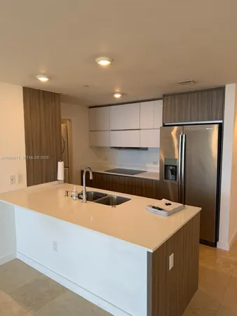 a kitchen that has a sink and a refrigerator