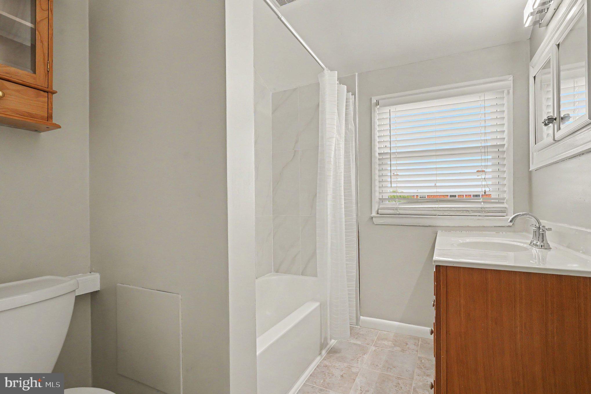 7729 Charlesmont Road Baltimore, MD 21222 - Photo 23 of 43 a bathroom with a sink a toilet and shower