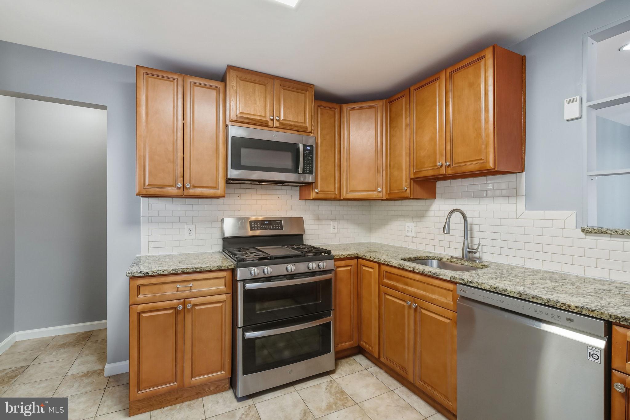 8817 Lagrange Street Lorton, VA 22079 - Photo 11 of 47 a kitchen with granite countertop a sink stove and microwave